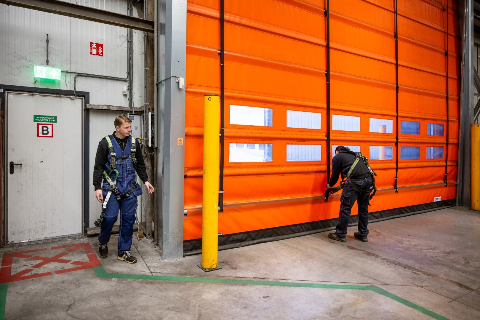 Matex monteurs controleren een geinstalleerde overheaddeur
